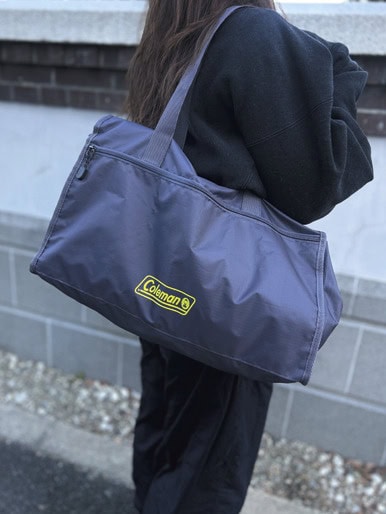 Colemanロゴ入りボストンバッグをトート持ちした着用イメージ