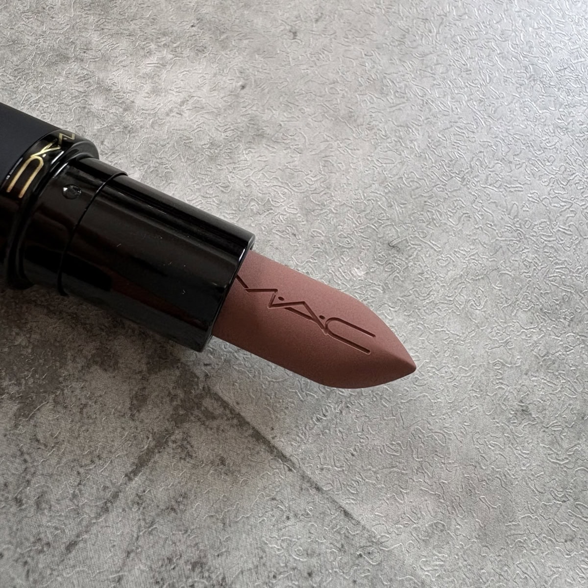 M·A·C パウダー キス ヘイジー マット リップスティック「テイケン」の先端アップ。やわらかなヌードブラウンカラー