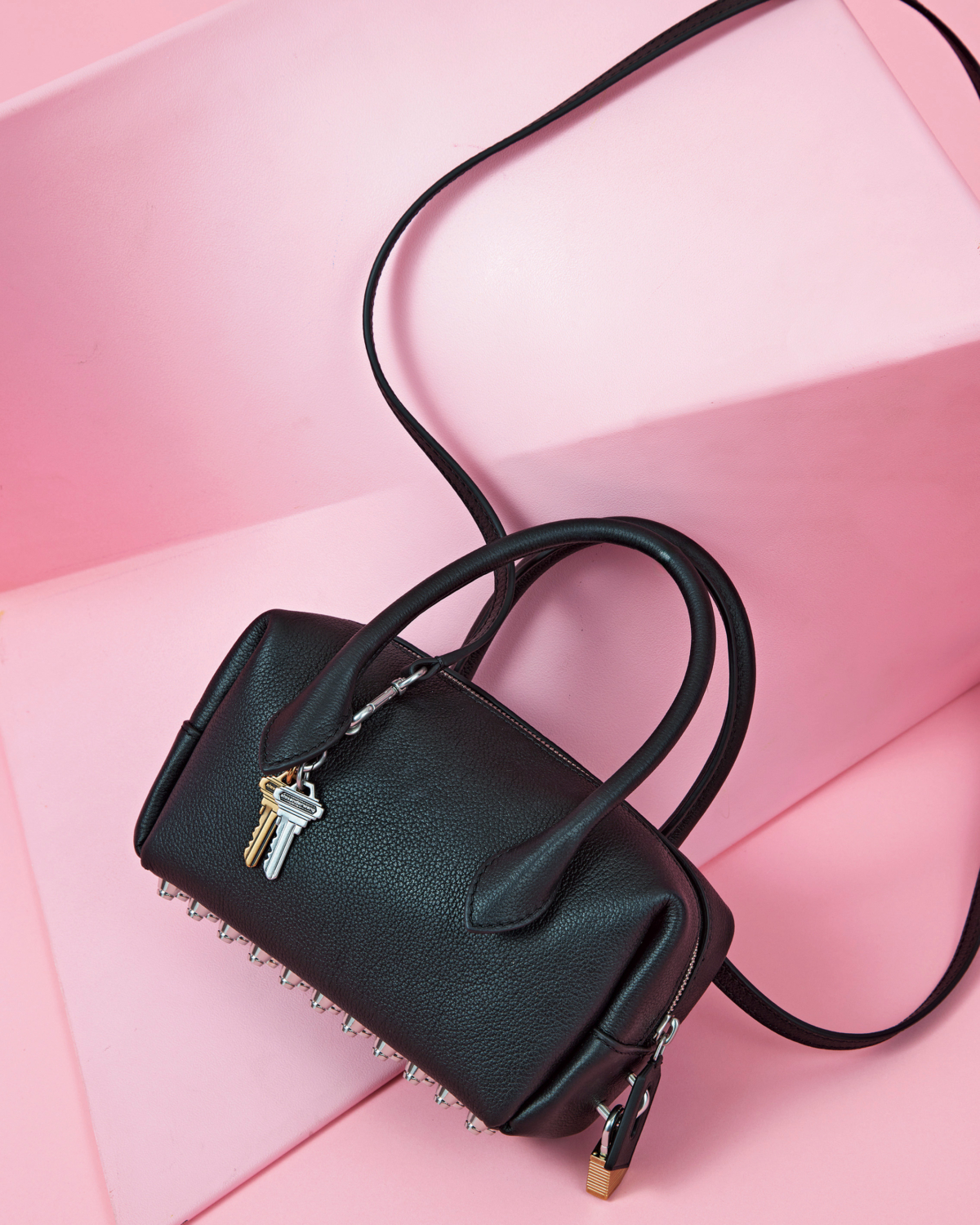 底面に軽量スタッズをあしらった横長シルエットバッグ。クラシックなフォルムにモードなエッジを効かせた、洗練されたミニバッグ。