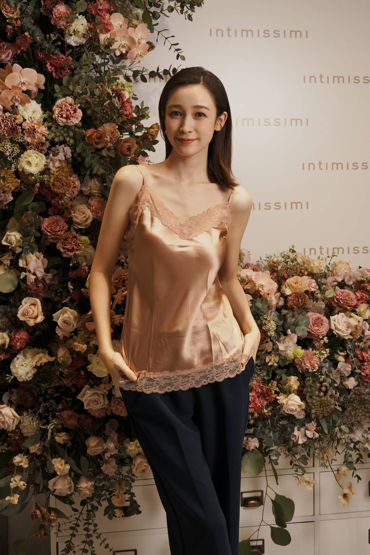 インティミッシミのレース&シルク トップを着用しポーズをとる藤井サチさん