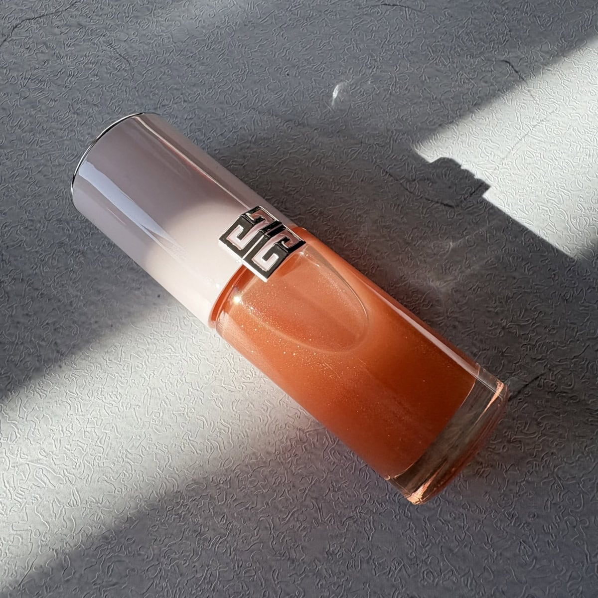 ジバンシイの、美容液のようなケア効果とメイクアップを両立したリップオイル、PFCT・セラム・リップオイル 04。柔らかなピーチ色。