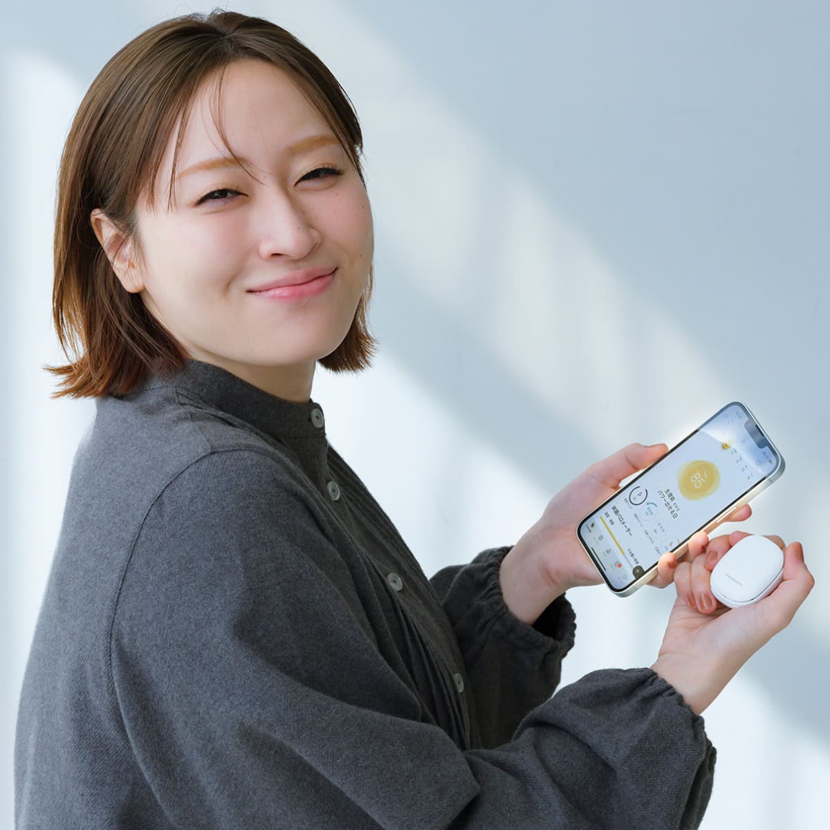 パナソニックの体調管理サービス「RizMo(リズモ)」とスマートフォンのアプリ画面を紹介する丸山礼さん