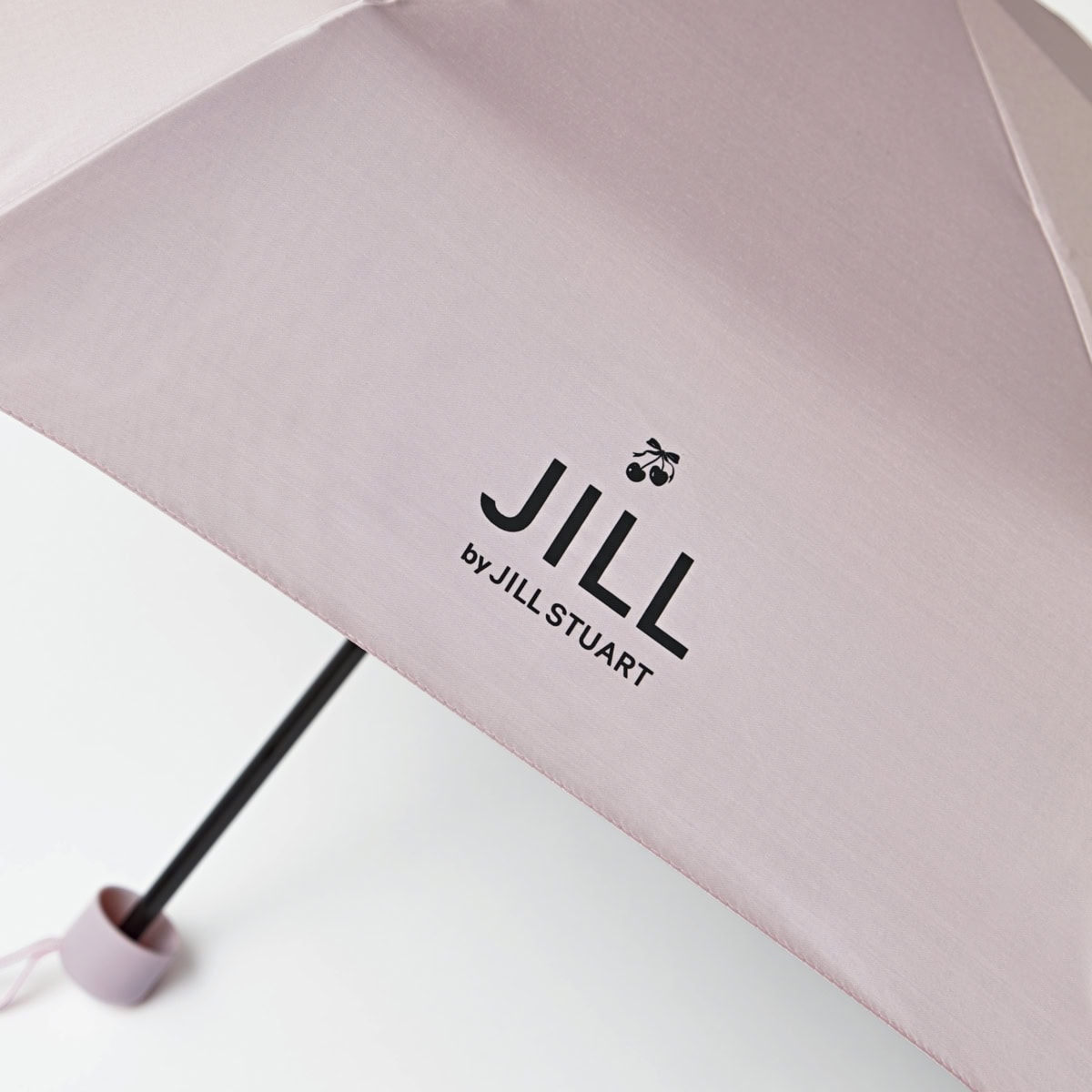 スウィート2026年5月号増刊号付録の、ジル バイ ジルスチュアートの晴雨兼用折り畳み傘のロゴアップ。さりげないチェリーのプリントが大人かわいさを演出。