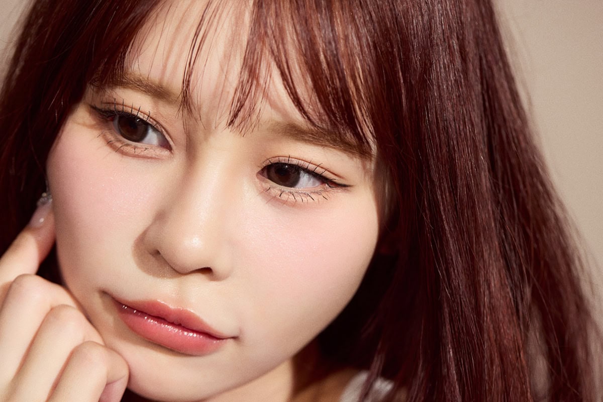 頬に手をあて、伏し目で極細ペンシルアイライナーのメイクの仕上がりを見せる村川緋杏のクローズアップ。