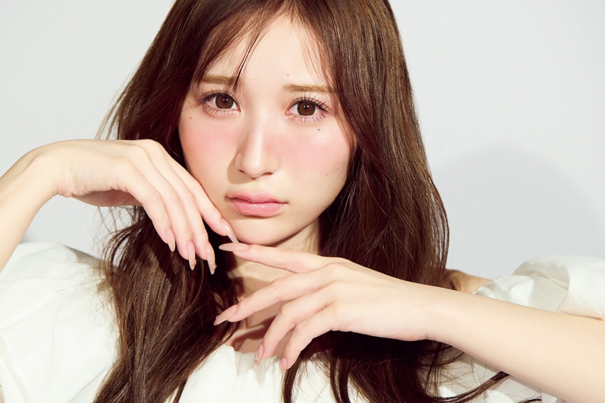 極細リキッドアイライナーでメイクし、頬に手をあてカメラ目線の小川奈々子さんのバストアップ。