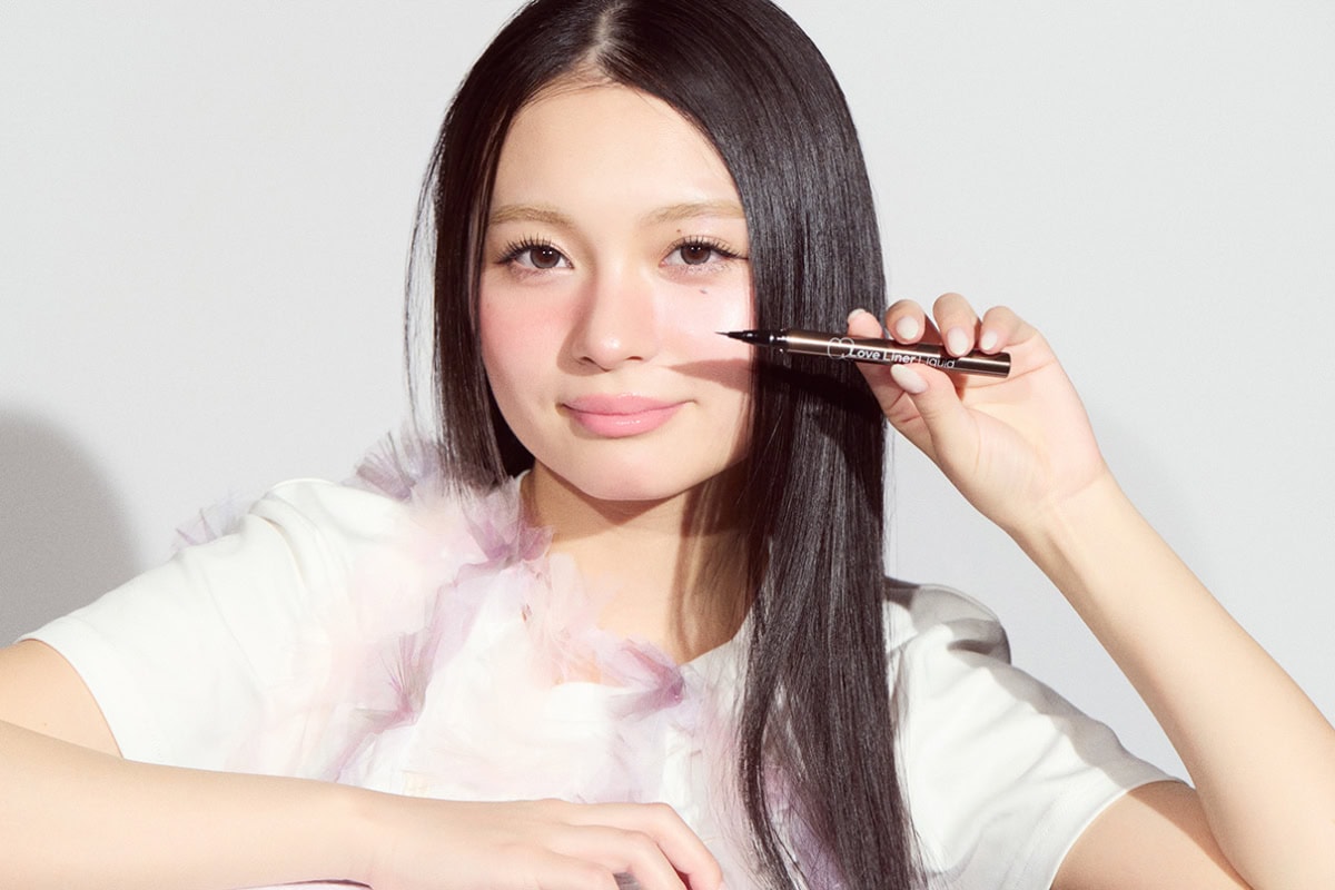 極細アイライナーを持ち、笑顔でカメラを見つめる桐原美月のポートレート。