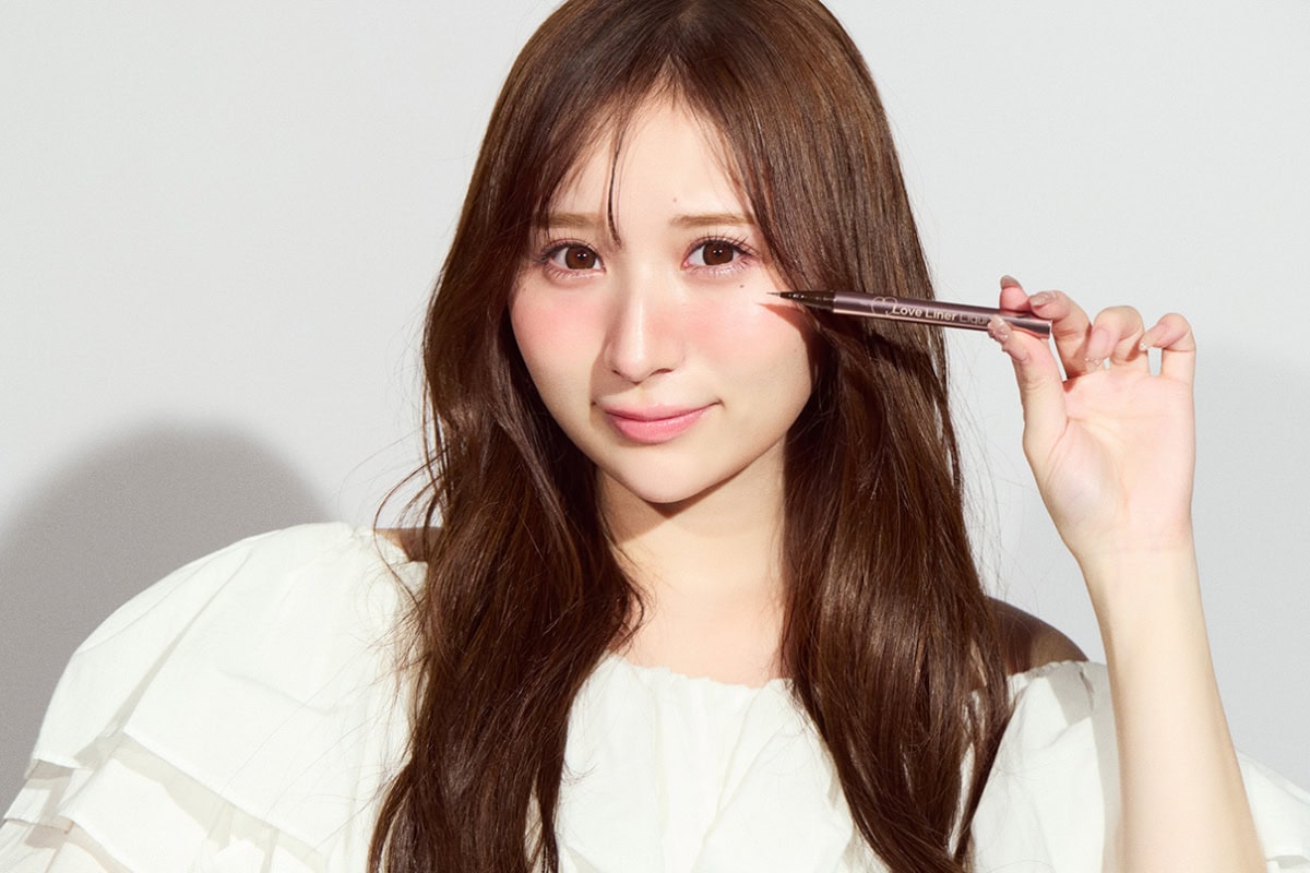 極細アイライナーを持ち、笑顔でカメラを見つめる小川奈々子のポートレート。