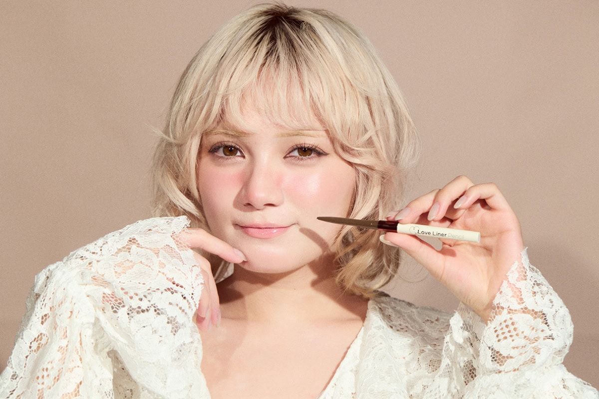 極細ペンシルアイライナーを持ち、笑顔でカメラを見つめる宮野静のポートレート。