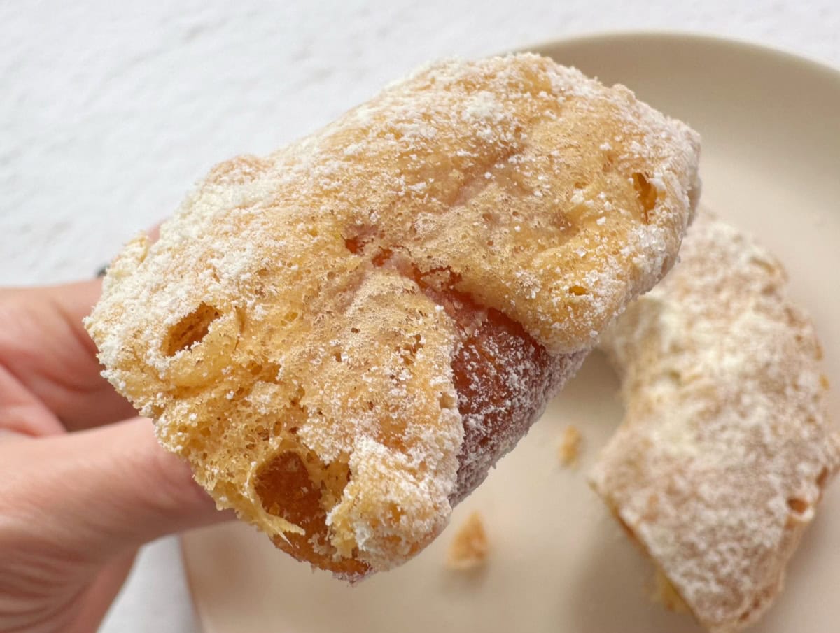 ドーナツの表面にオリジナルの液をつけてフライした後、シュガーをたっぷりとまぶしている