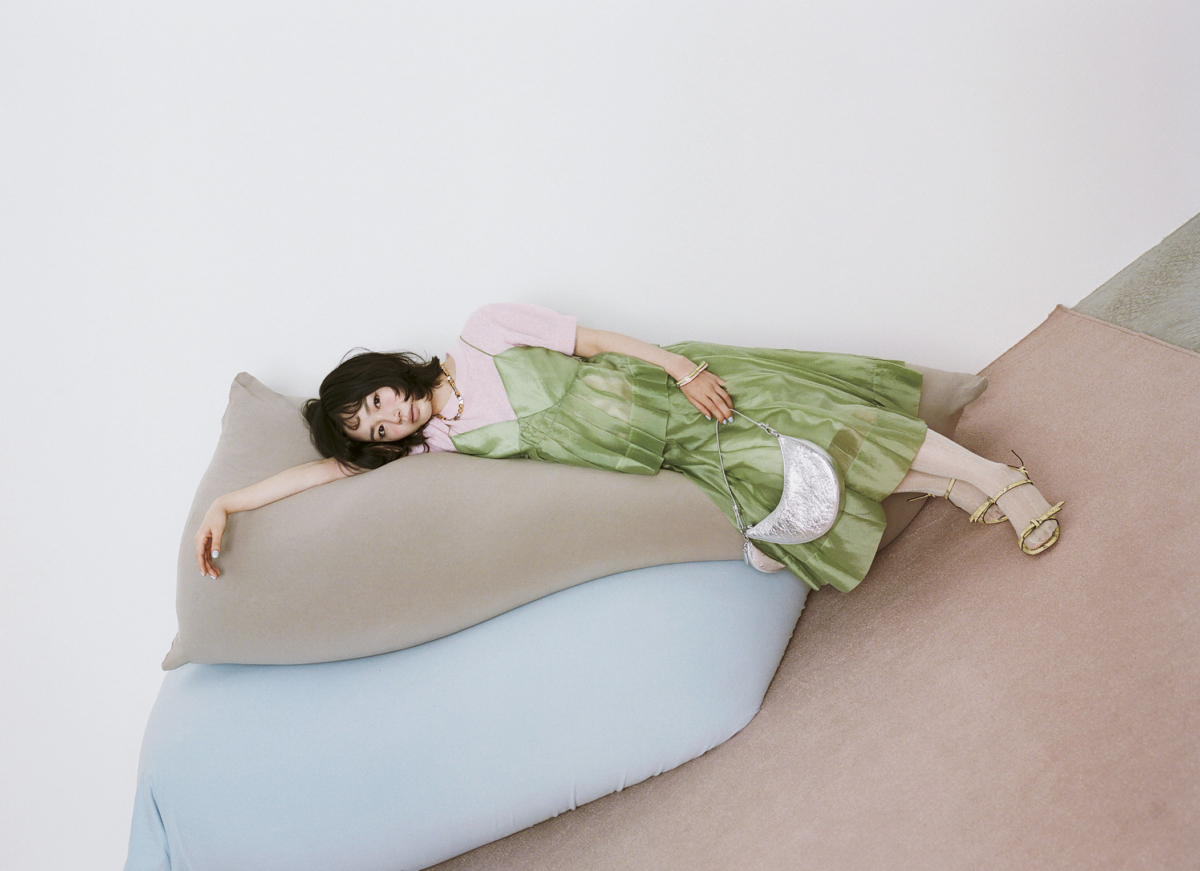 ケイト・スペードの26SSコレクション、ピスタチオカラーのセットアップを纏い横になってポーズをとる宮崎優の春ルック。
