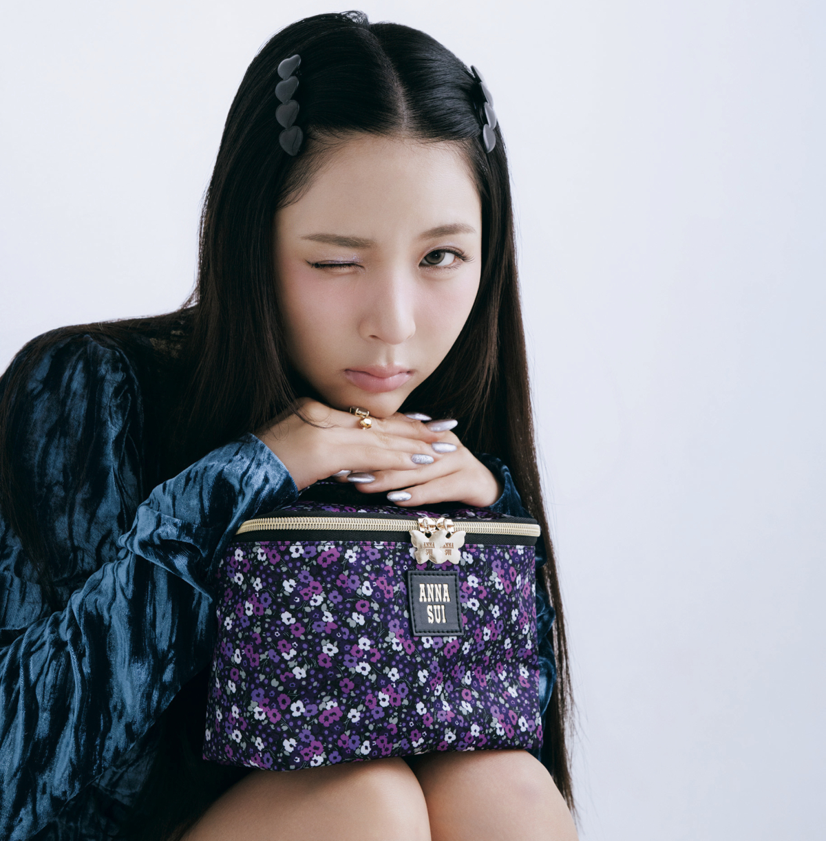 アナ スイの新作秋コスメでメイクをしたミミチちゃんがANNA SUIの花柄バニティポーチに顎をのせてウインクしているカット