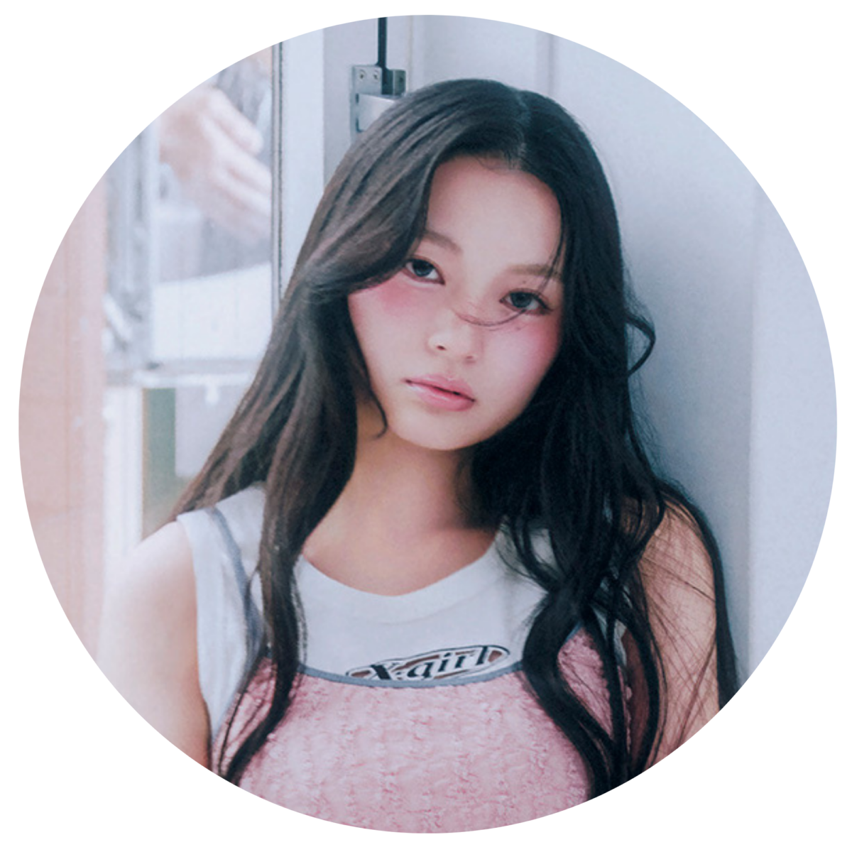 X-girlのロゴ入り白タンクトップにピンクのビスチェを重ね着し、ロングヘアでカメラを見つめる、CANDY TUNE・桐原美月さんのプロフィール用丸型ポートレート写真