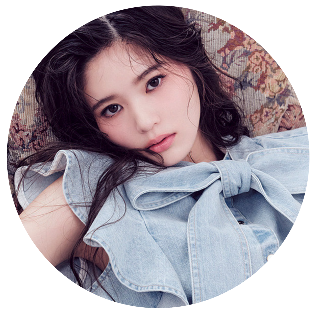 デニムトップスを着て横たわりカメラを見つめる、CIRRA・TOAさんのプロフィール用丸型ポートレート写真