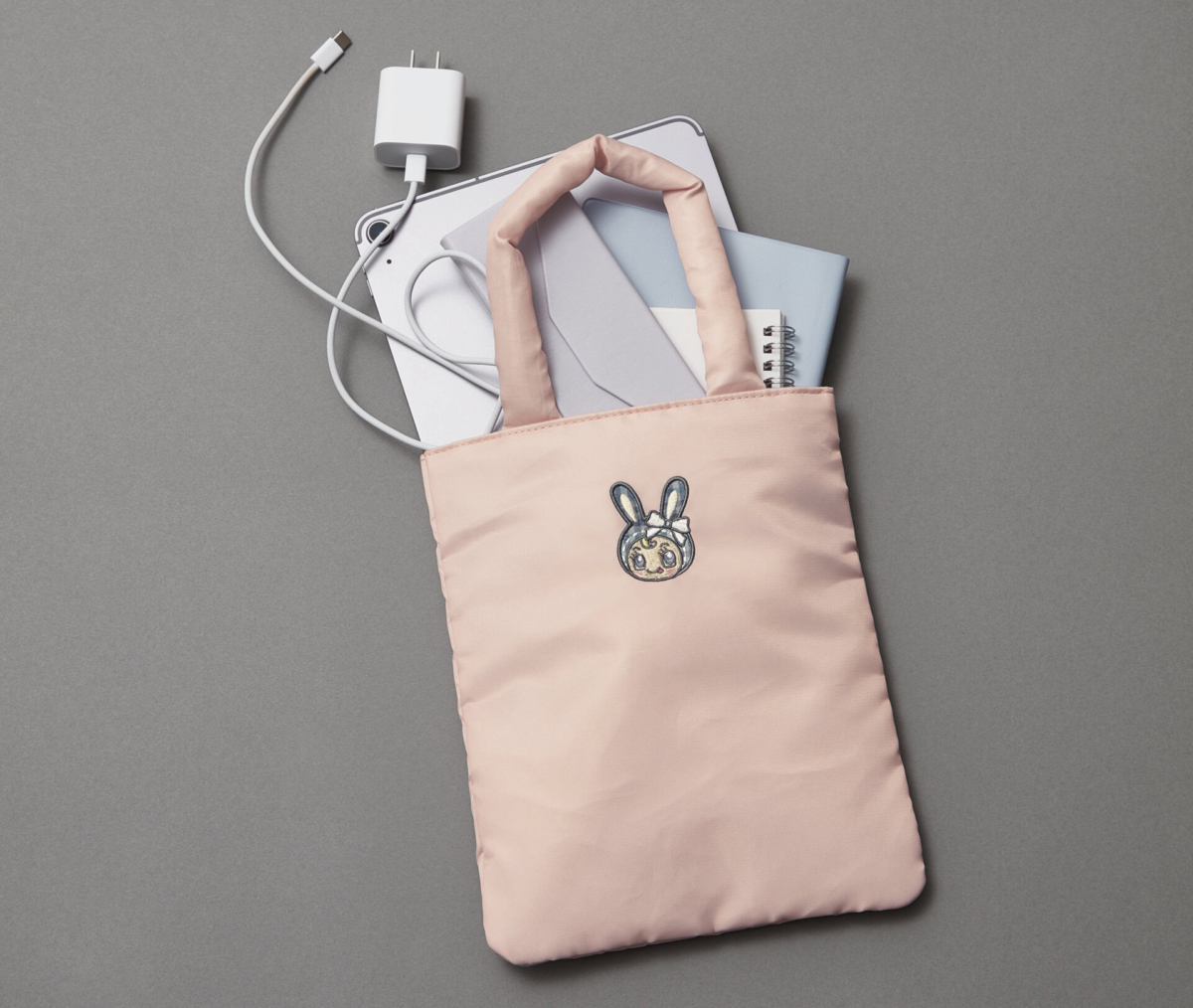 ベリエちゃん刺繍のふかふかトートバッグに、11インチ相当のタブレットや充電ケーブル、ノートがすっぽり収納されている様子。