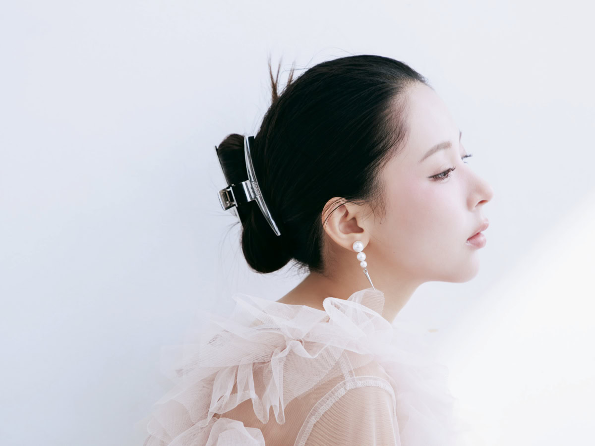 バンスクリップでまとめ、毛先を立たせたタイトシニヨンのサイドスタイル