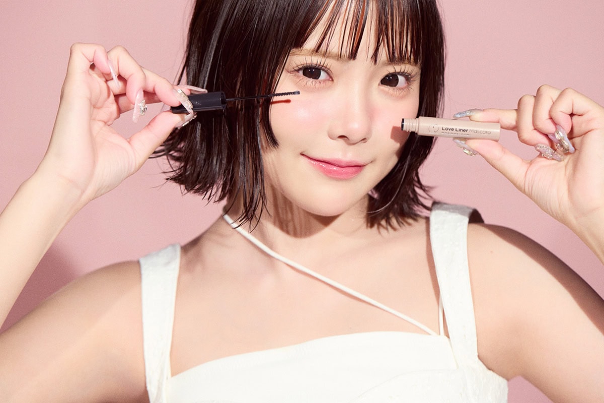 マスカラを手に持ち、首を少し傾けて微笑む福山梨乃のポートレート。