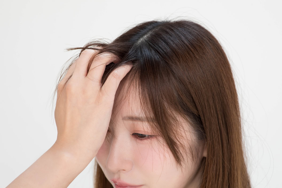 スプレーしたドライシャンプー「バティスト」のパウダーを、指の腹を使って根元にササッとなじませる工程
