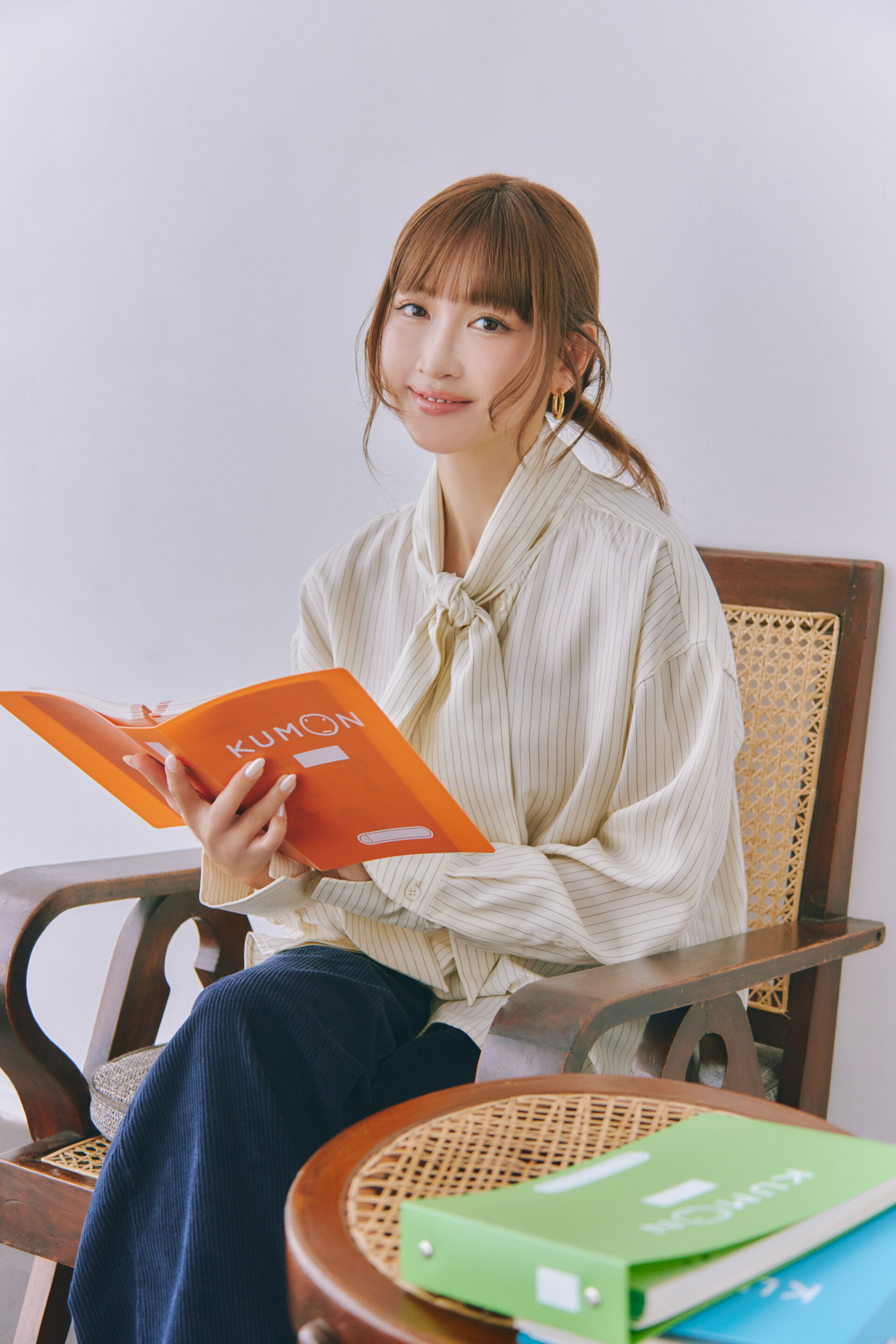 【紗栄子】が語る、KUMON(公文)と子育て|自己肯定感を育む習いごと。紗栄子さんが教材を持つ画像。