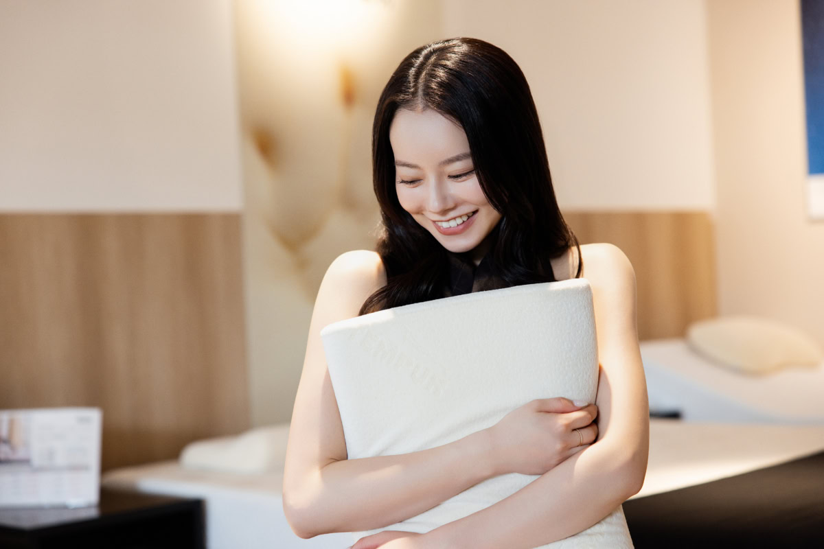 TEMPURのオリジナルピローを胸に抱きフィット感に満足気な笑顔を見せるなごみちゃん