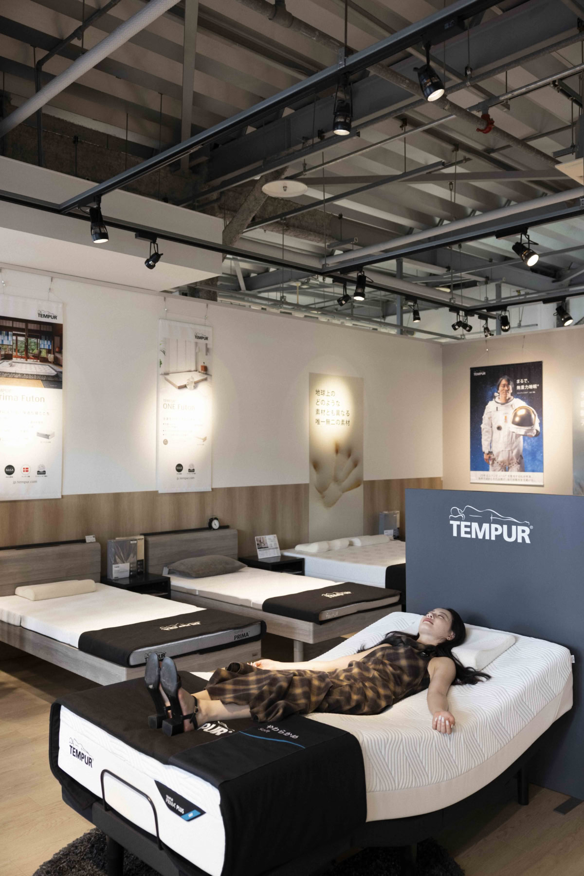 TEMPUR店内のリクライニングベッドに横たわり無重力睡眠を体験するなごみちゃん